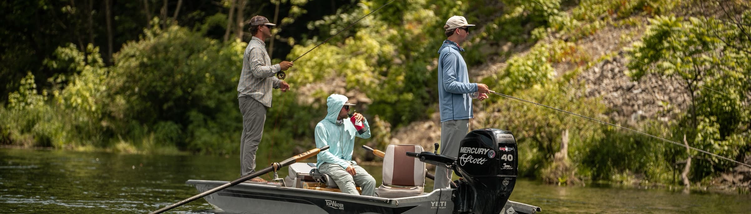 Two anglers fishing a summer river from a jon boat