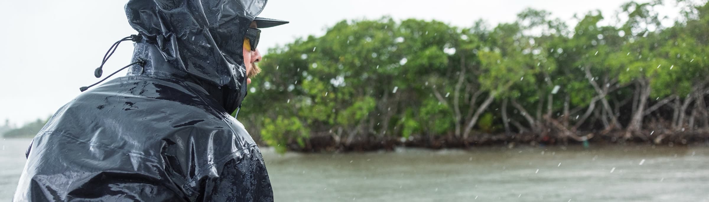 A hooded angler casting through the rain